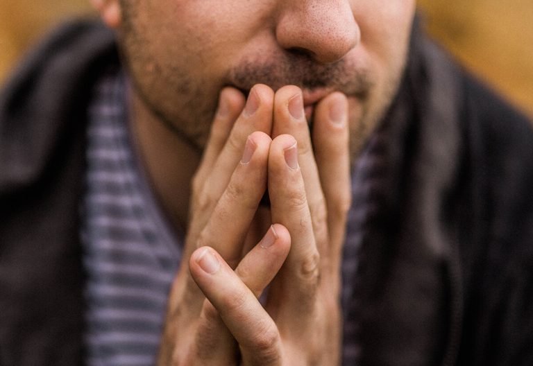 a close up of a person holding their hands together.