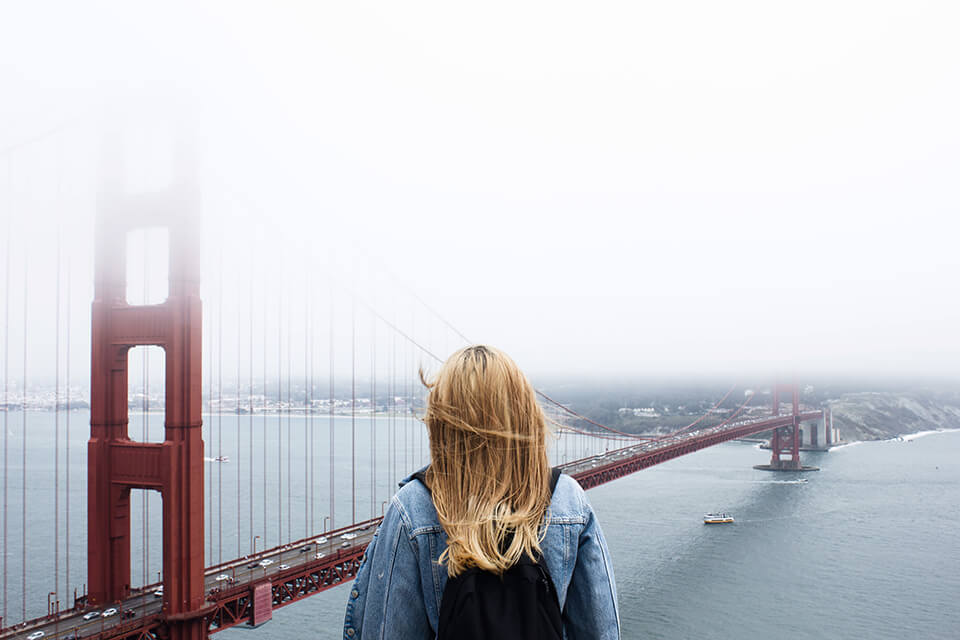 Woman staring off into the distance looking at a bridge