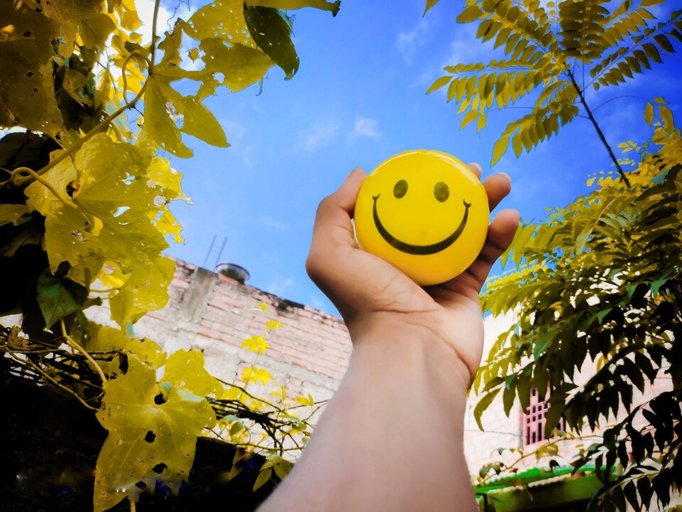 Holding a ball with a smiley face on it