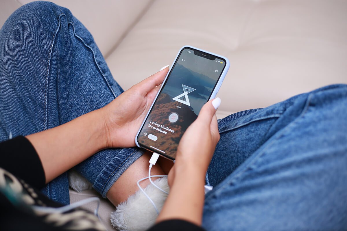 a person sitting on a couch holding a cell phone.