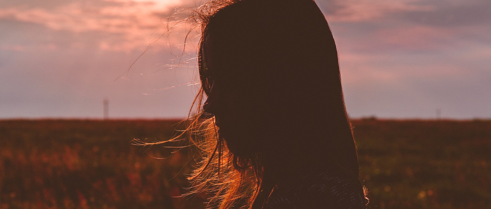 a woman standing in a field of tall grass.