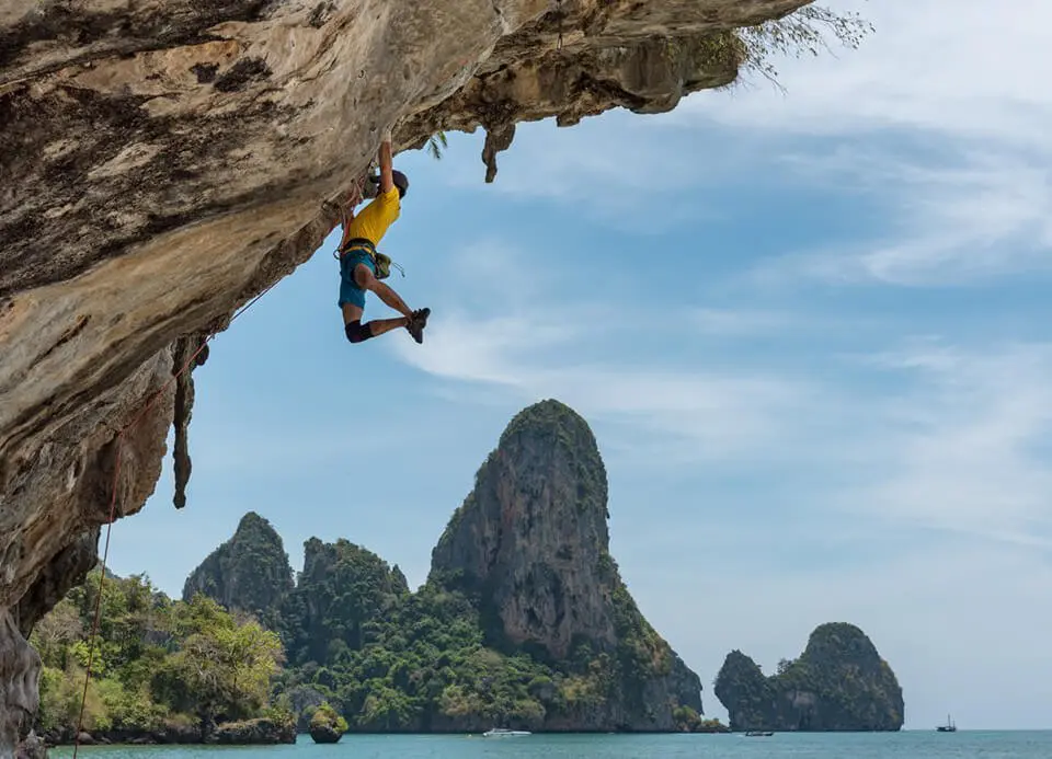 Man rock climbing up a steep cliff