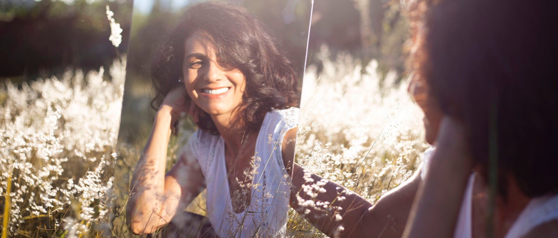 a woman sitting in a field of tall grass.