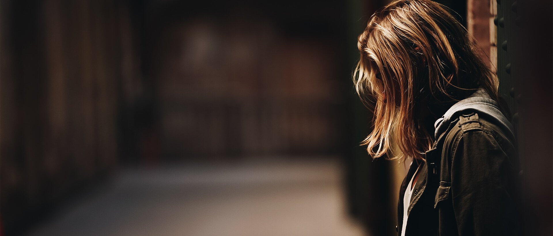 a woman standing in a hallway with her back to the camera.