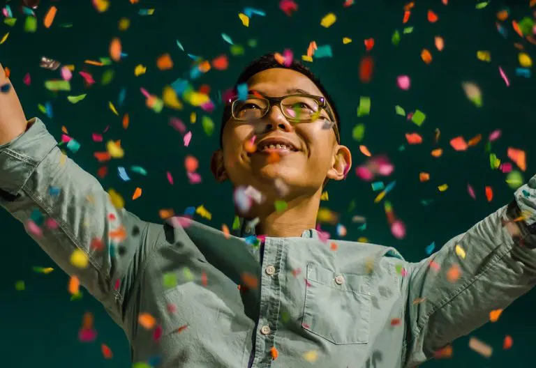 a man standing in front of confetti falling from his hands.