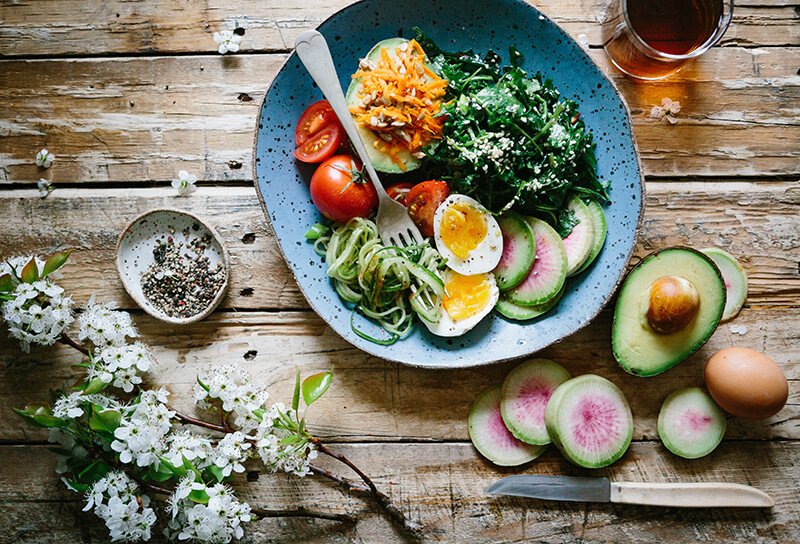 Table with plate full of vegetables and eggs