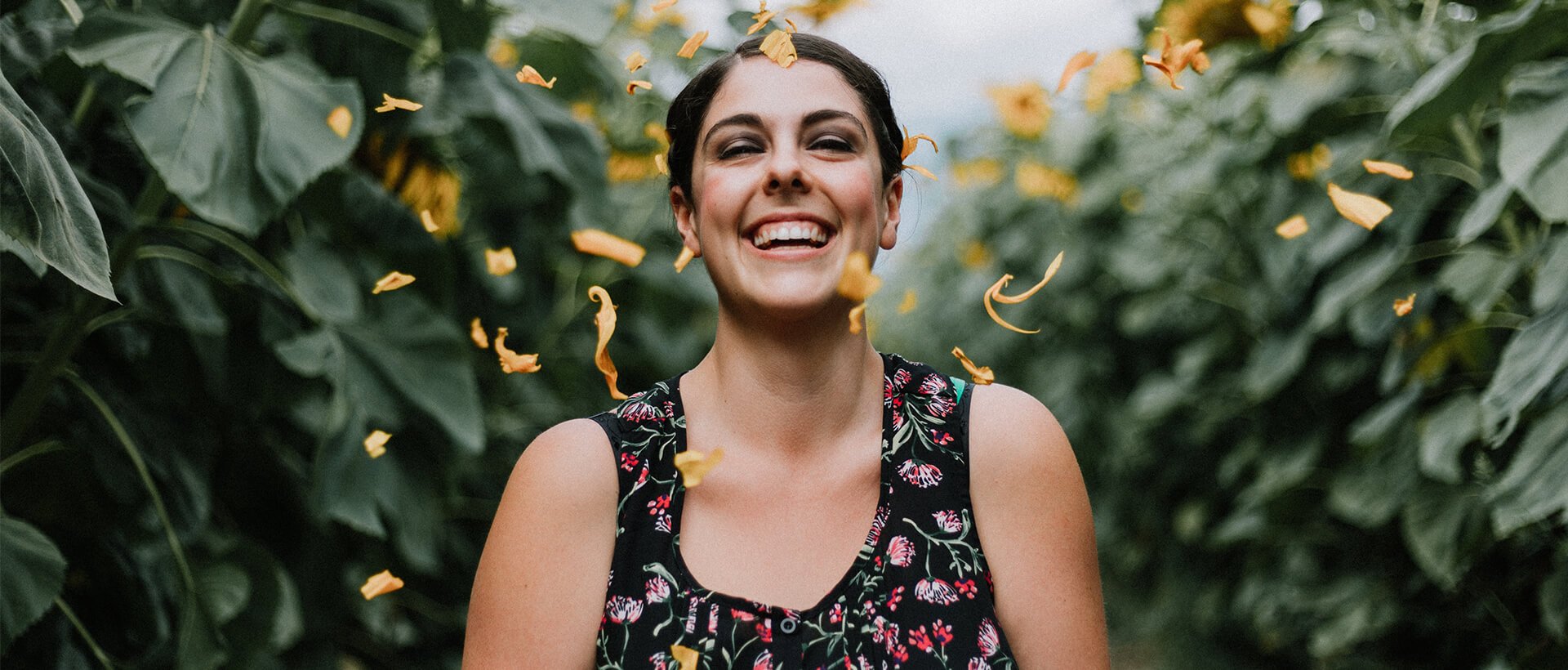 a woman standing in front of a field of sunflowers.