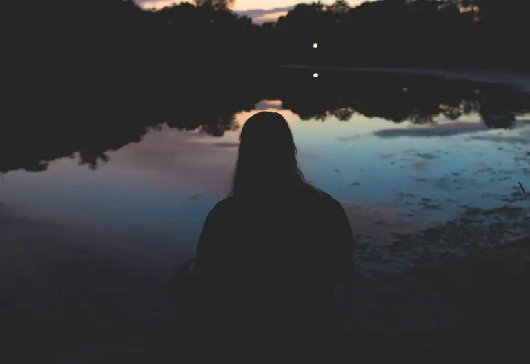 a person standing in front of a body of water.