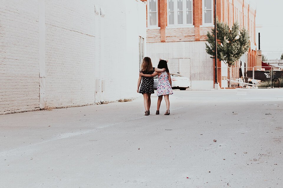 Two little girls walking arm in arm