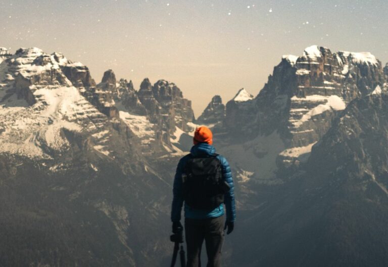 a man standing on top of a snow covered mountain.