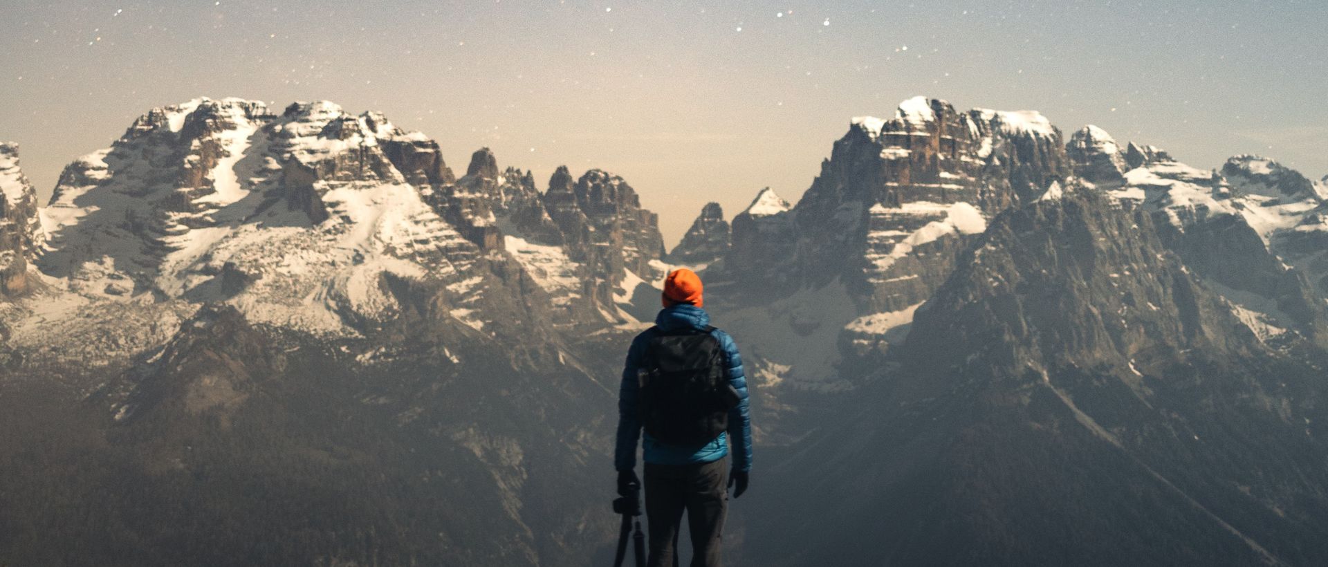 a man standing on top of a snow covered mountain.