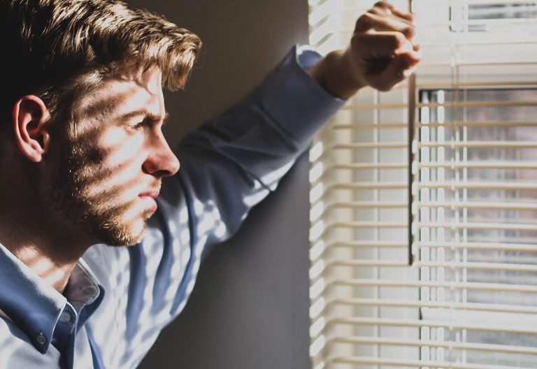 a man is looking out of a window.