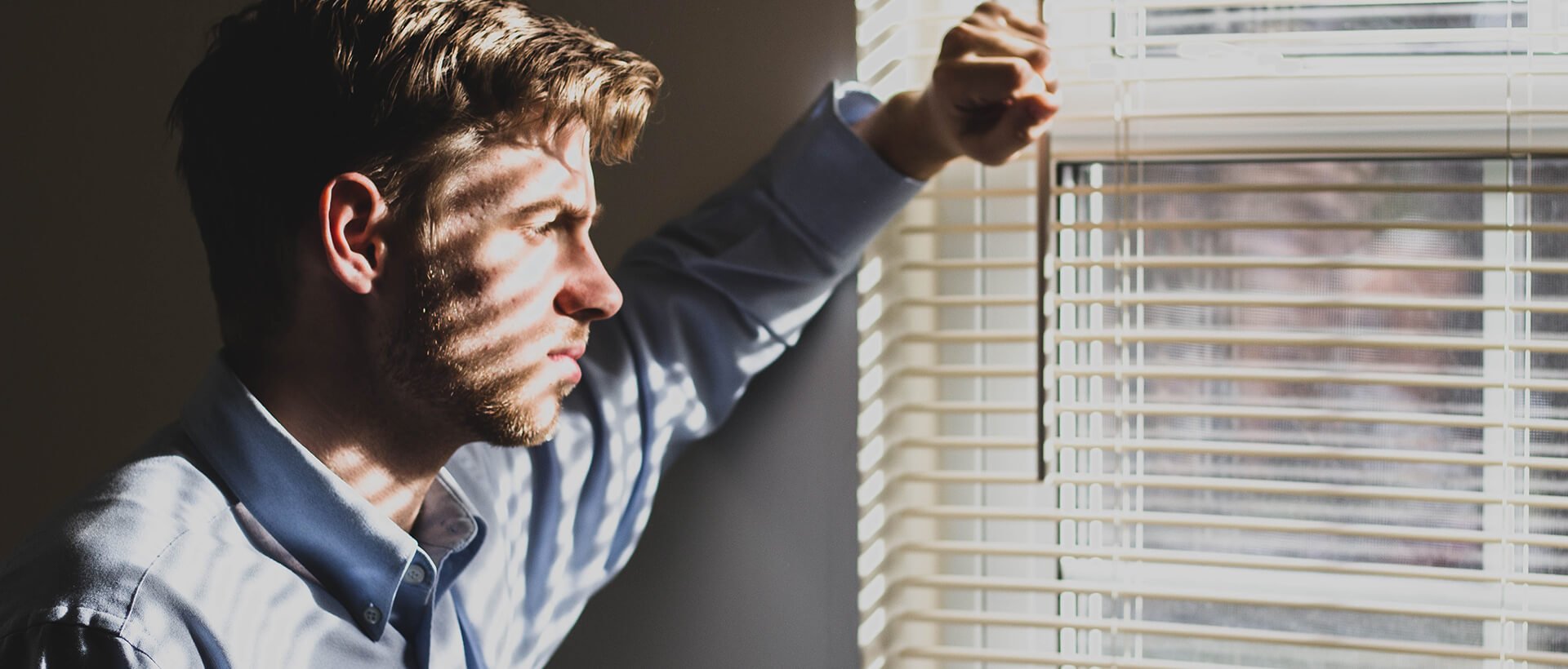 a man is looking out of a window.