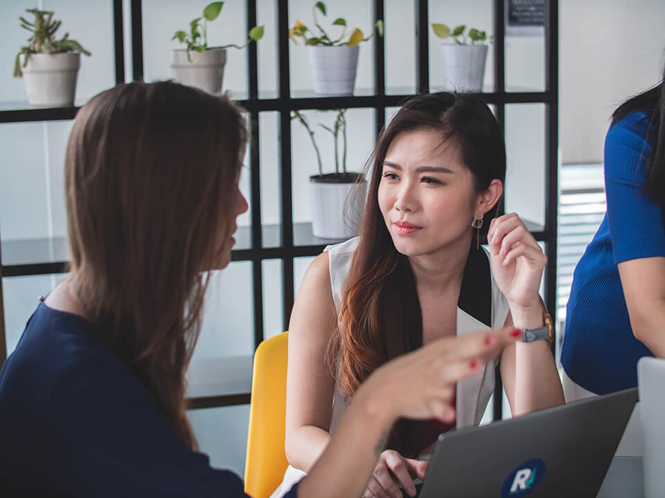 Woman listening to her colleague explaining a problem