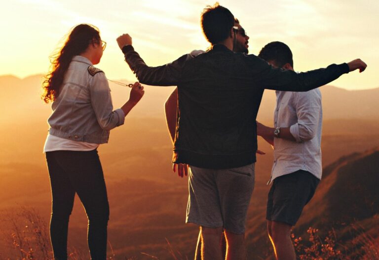 a group of people standing on top of a mountain.