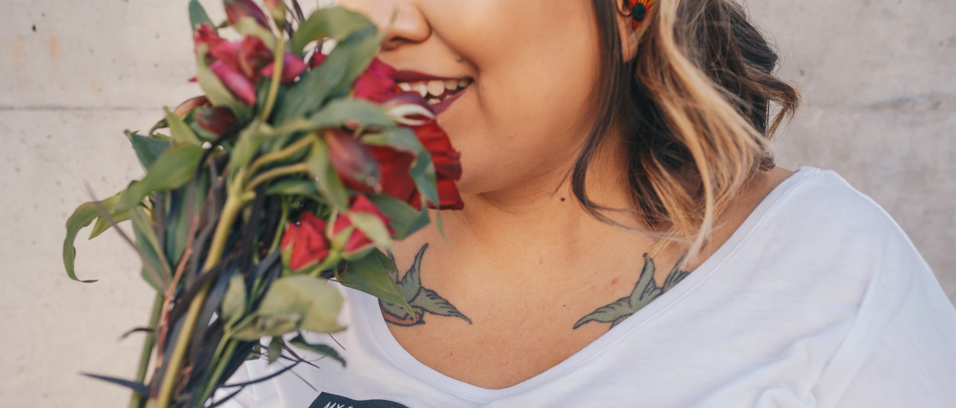 a woman holding a bouquet of flowers in front of her face.