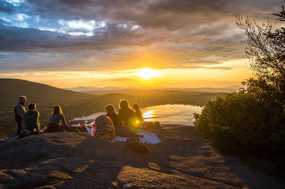 Group of friends having a picnic by a scenic landscape