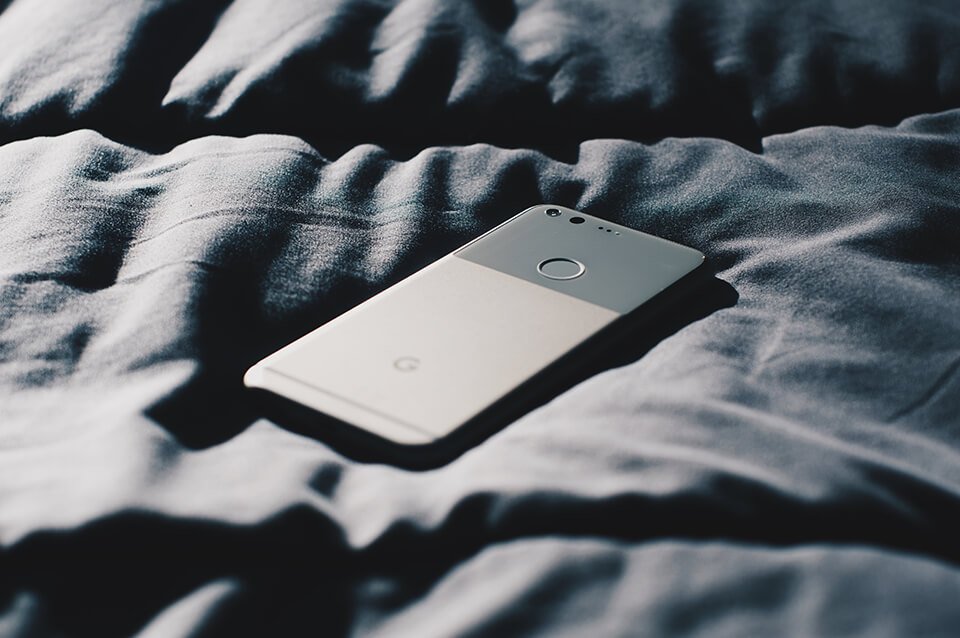 a cell phone laying on top of a bed.