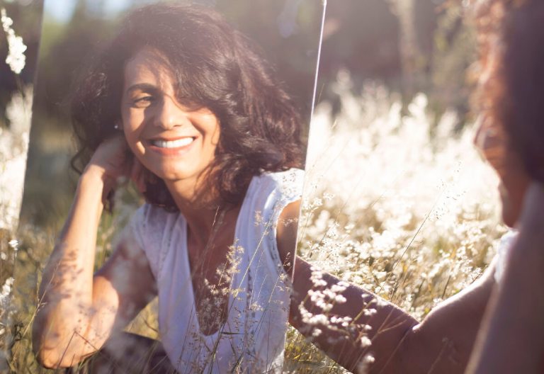 a woman sitting in a field of tall grass.