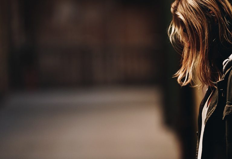 a woman standing in a hallway with her back to the camera.