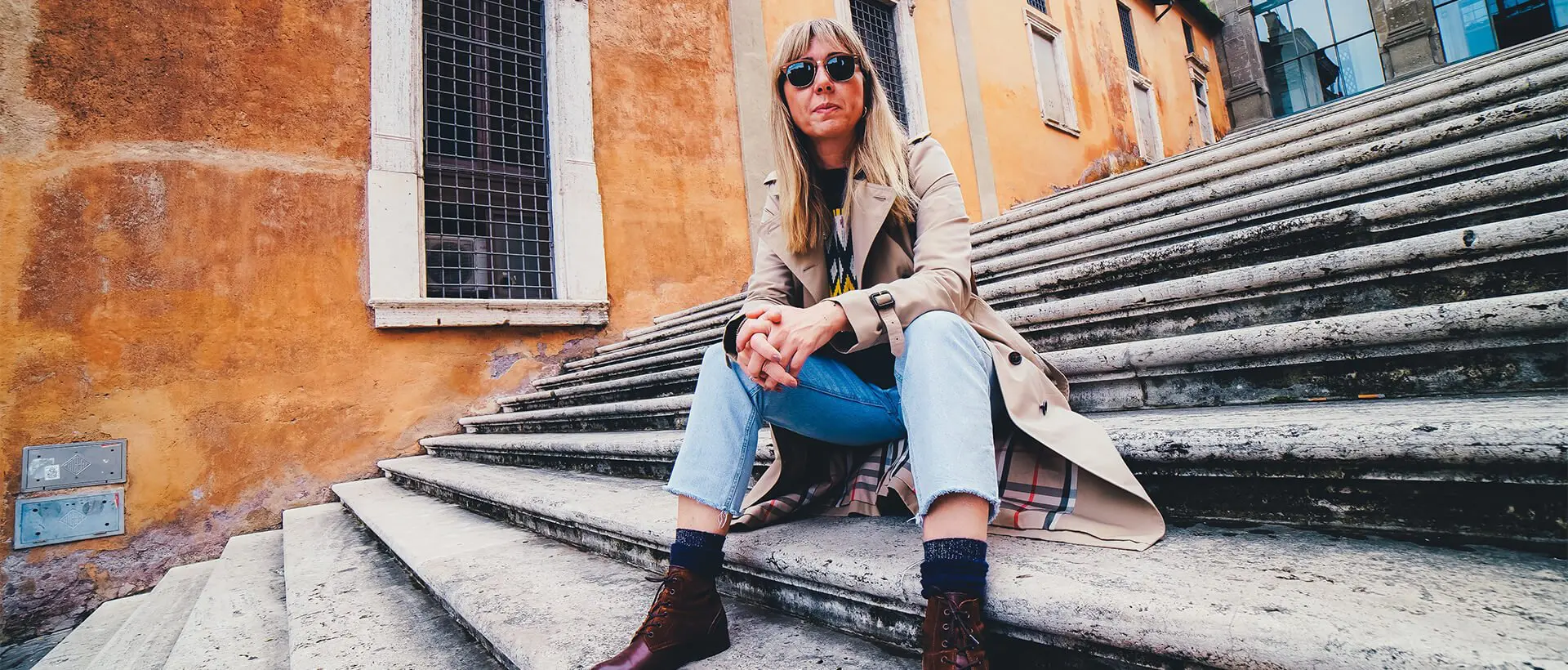 a woman sitting on the steps of a building.