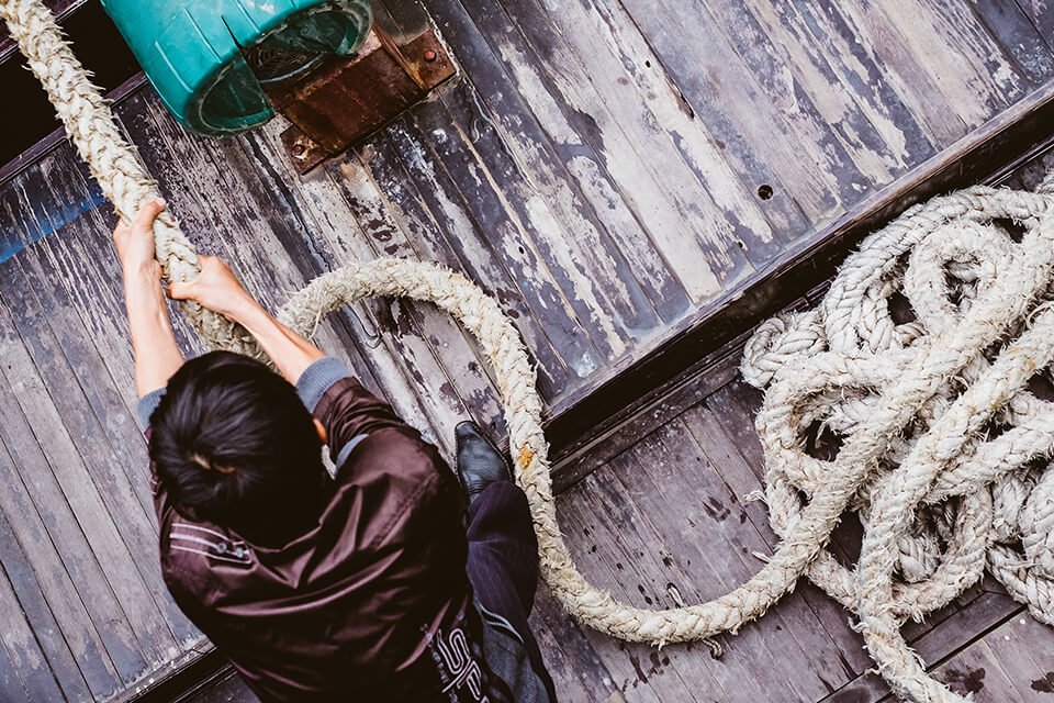 Man pulling on rope on dock