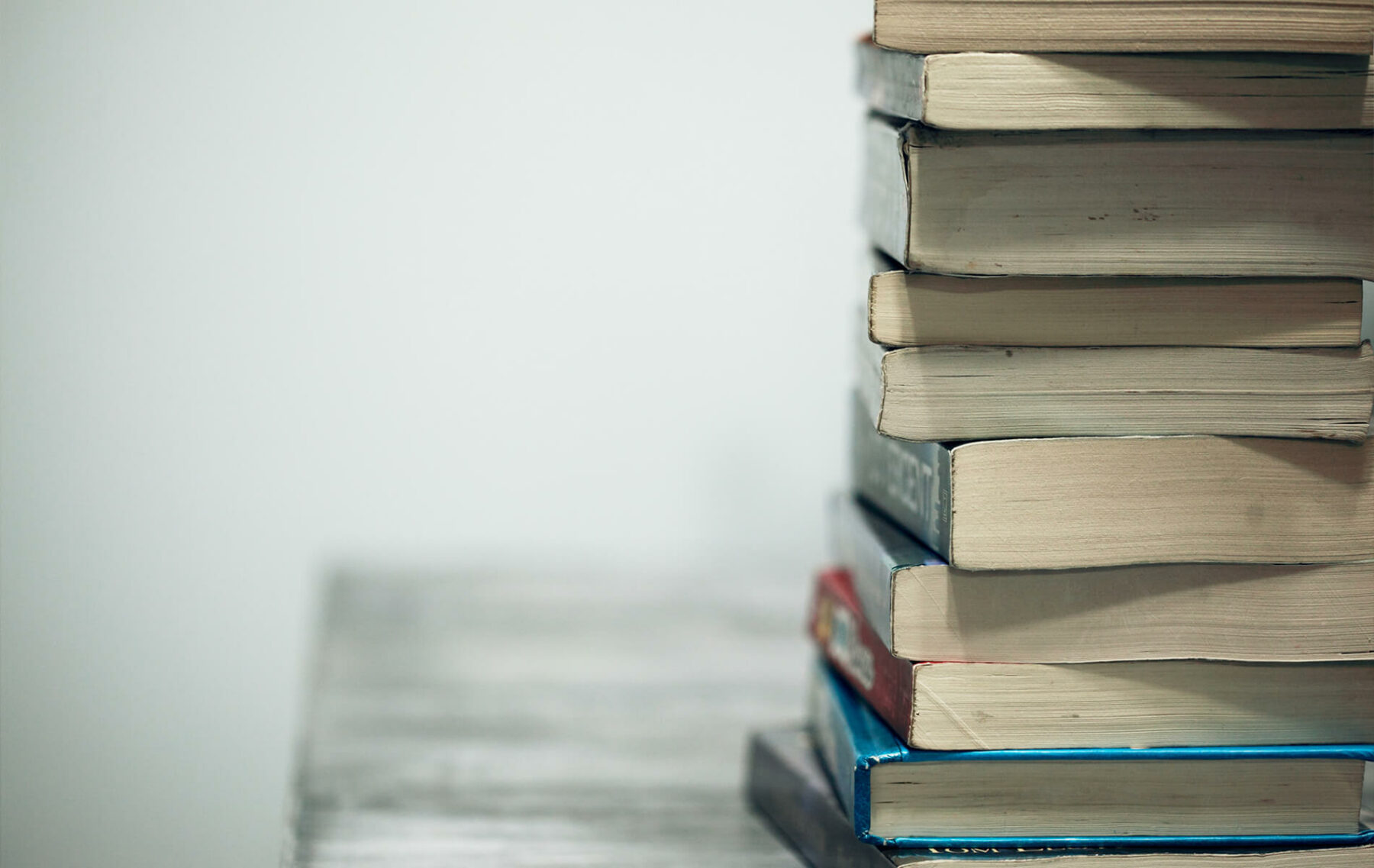 a stack of books sitting on top of a table.