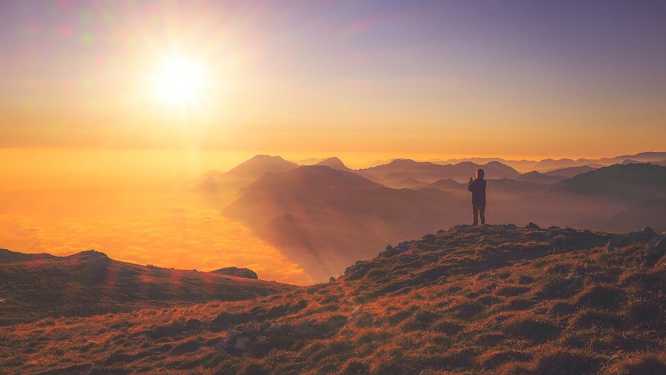 Woman taking a photo of the setting sun