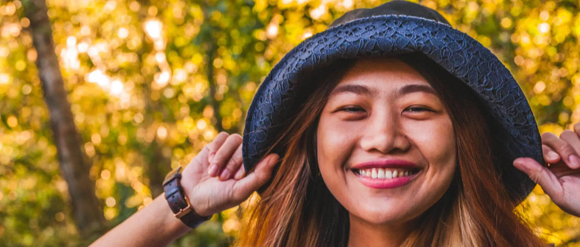 a woman wearing a hat and smiling for the camera.