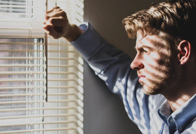 a man is looking out of a window.