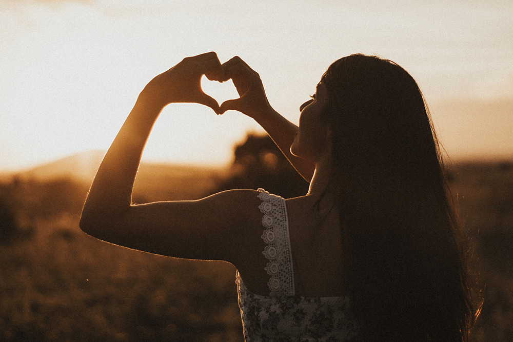 woman making heart shape with hand