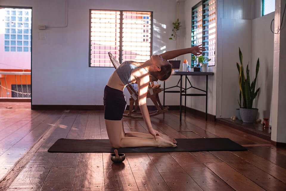 Woman doing yoga inside her home