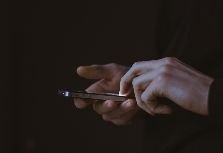 a person holding a cell phone in their hands.