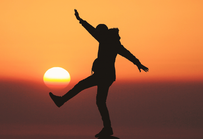 a person jumping in the air at sunset.