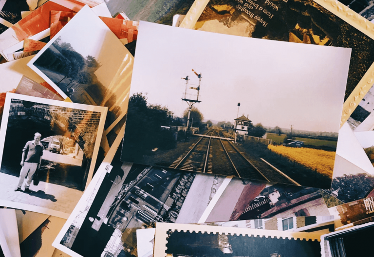 a pile of old photos and postcards sitting on top of a table.