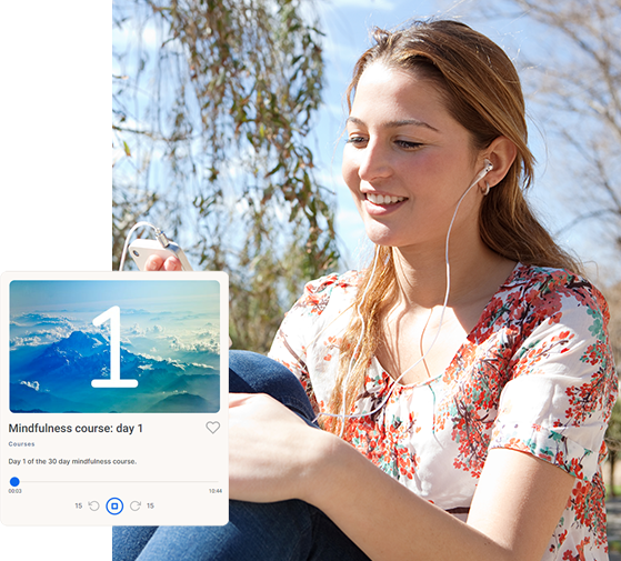 a woman sitting on the ground looking at her cell phone.