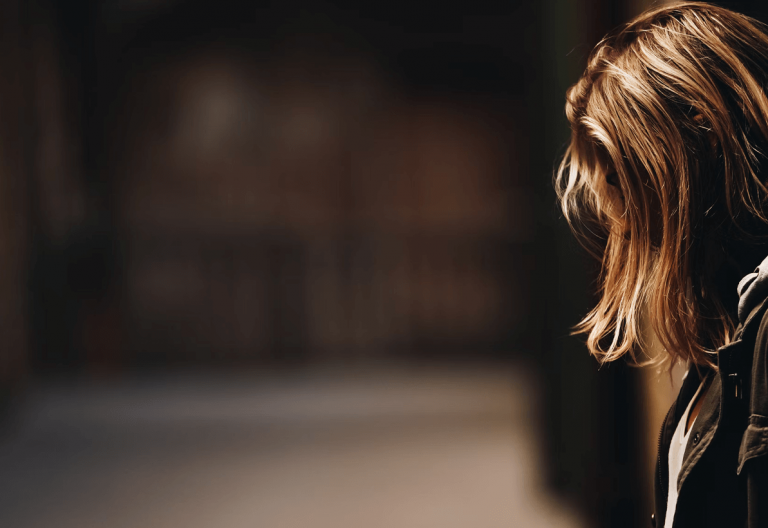 a woman standing in a hallway with her back to the camera.